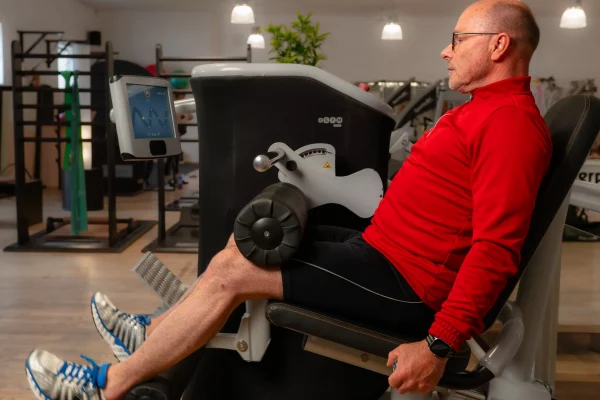 Ein Mann trainiert seine Beinmuskulatur an einem eGym-Gerät im Physioaktiv Sportsclub.